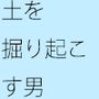 白っぽくも茶色い川辺の土をなぜか掘り起こす男